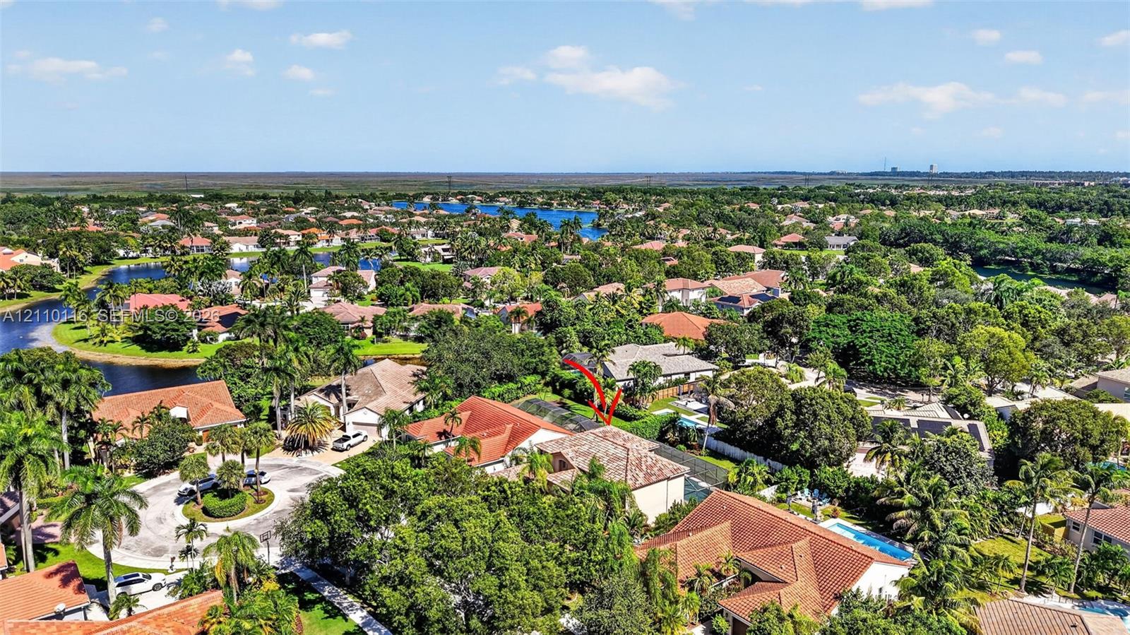 Aerial perspective of a multi-level residence featuring a multi-pitched tile roof and a screened-in rear enclosure