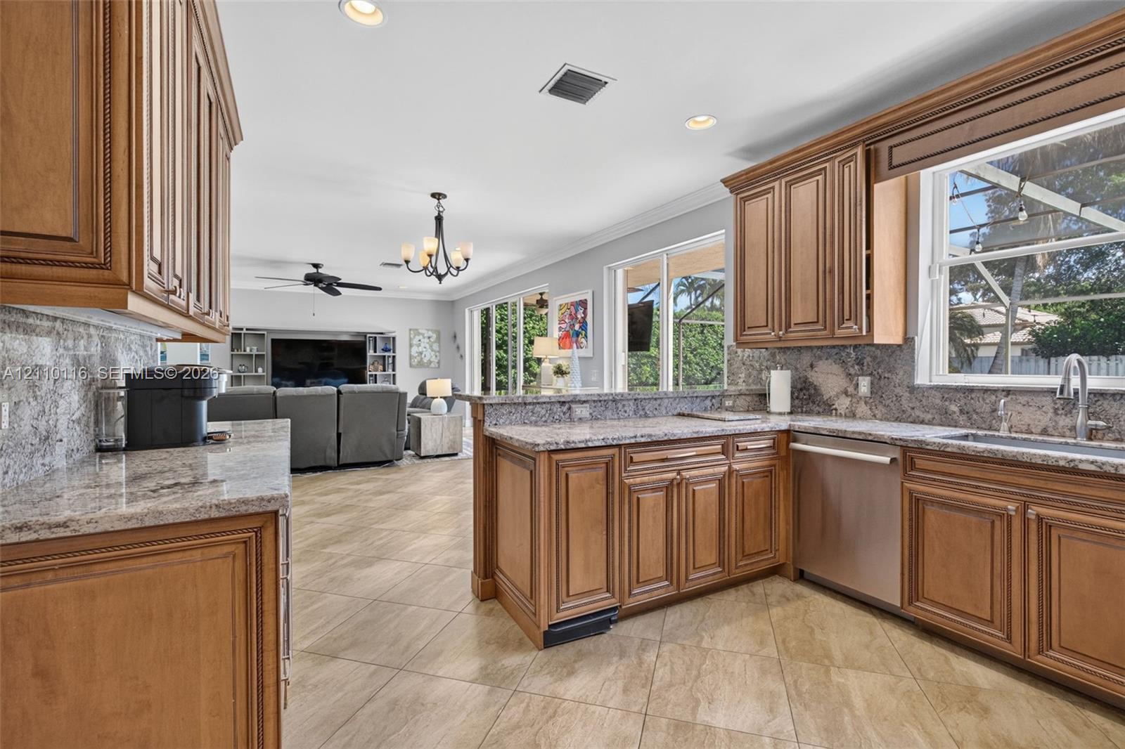 Kitchen featuring raised-panel wood cabinetry, stone countertops, stainless steel dishwasher, tile flooring, and recessed lighting