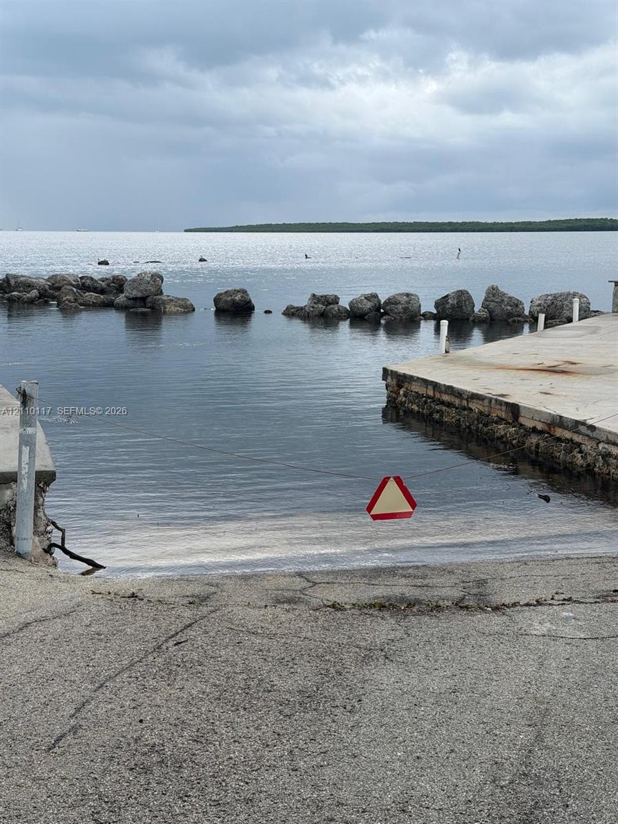Waterfront boat ramp featuring concrete landing, stone breakwater, and open water access