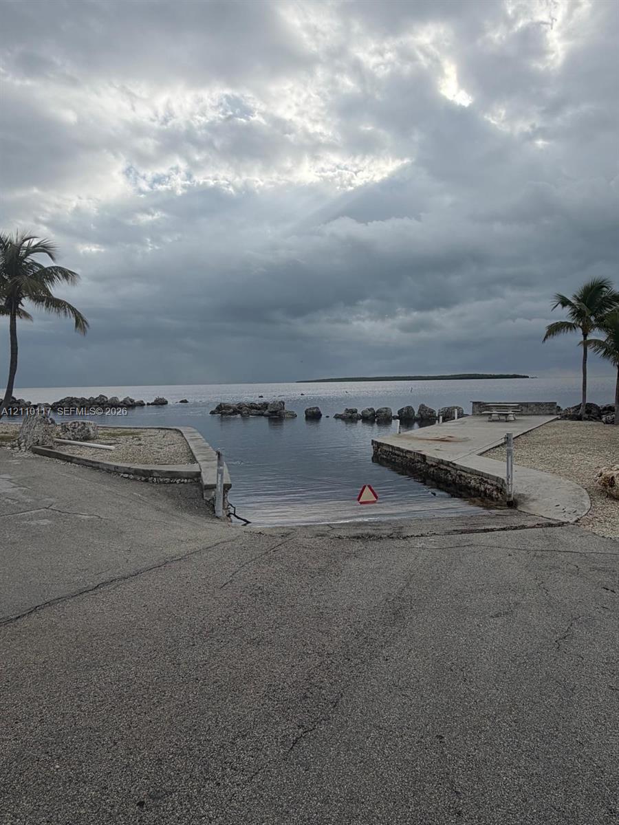 Private boat ramp featuring a concrete slipway, stone shoreline stabilization, and integrated waterfront bulkhead