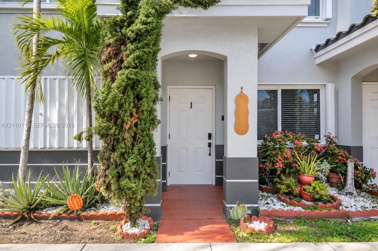 Covered entryway with arched architectural detailing, tile flooring, and integrated overhead lighting