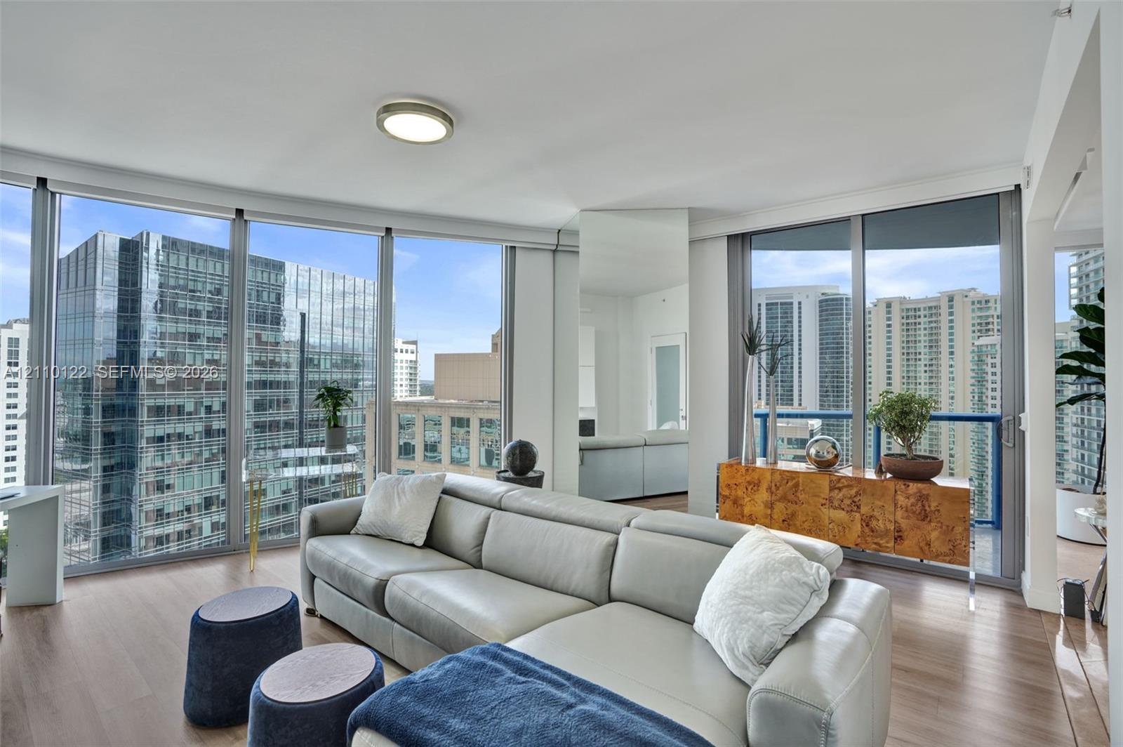 Floor-to-ceiling windows, wood-finish flooring, and recessed ceiling lighting