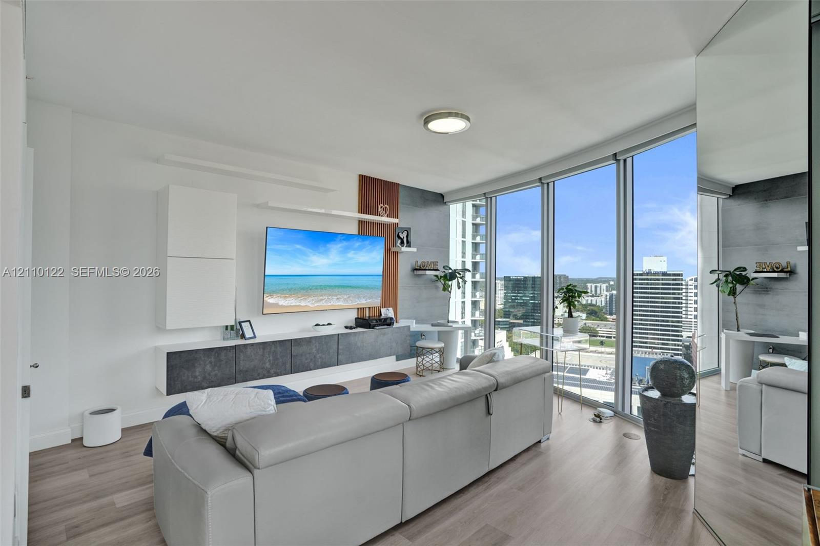 Floor-to-ceiling windows, wood-finish flooring, built-in wall cabinetry, and accent wall paneling