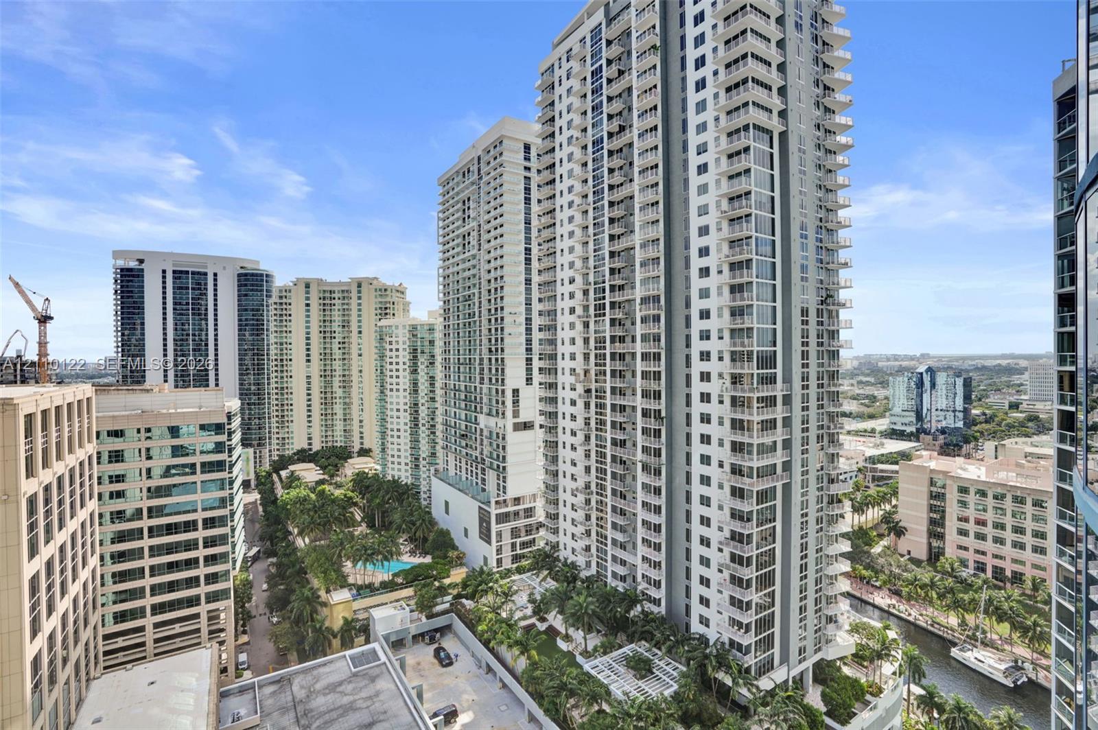 High-rise residential exterior featuring expansive glass facades, wrap-around balconies, and an urban landscape setting
