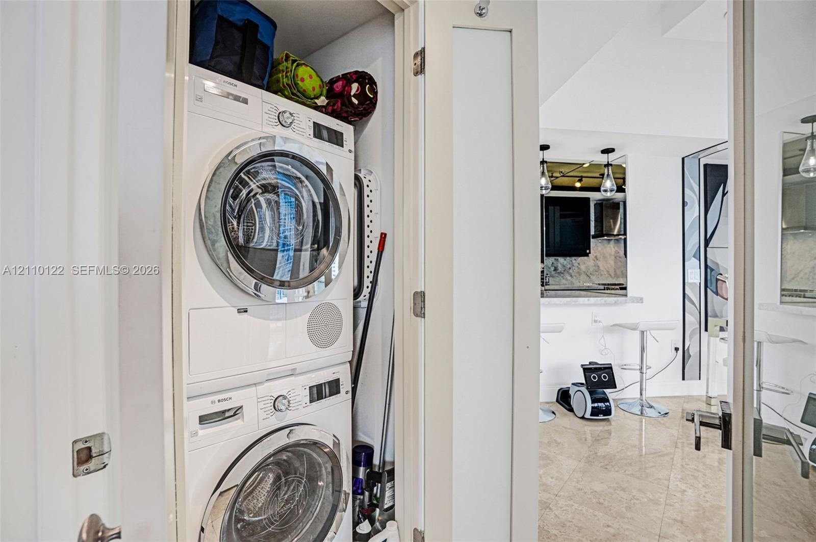 Stackable Bosch front-load washer and dryer unit housed within a dedicated closet