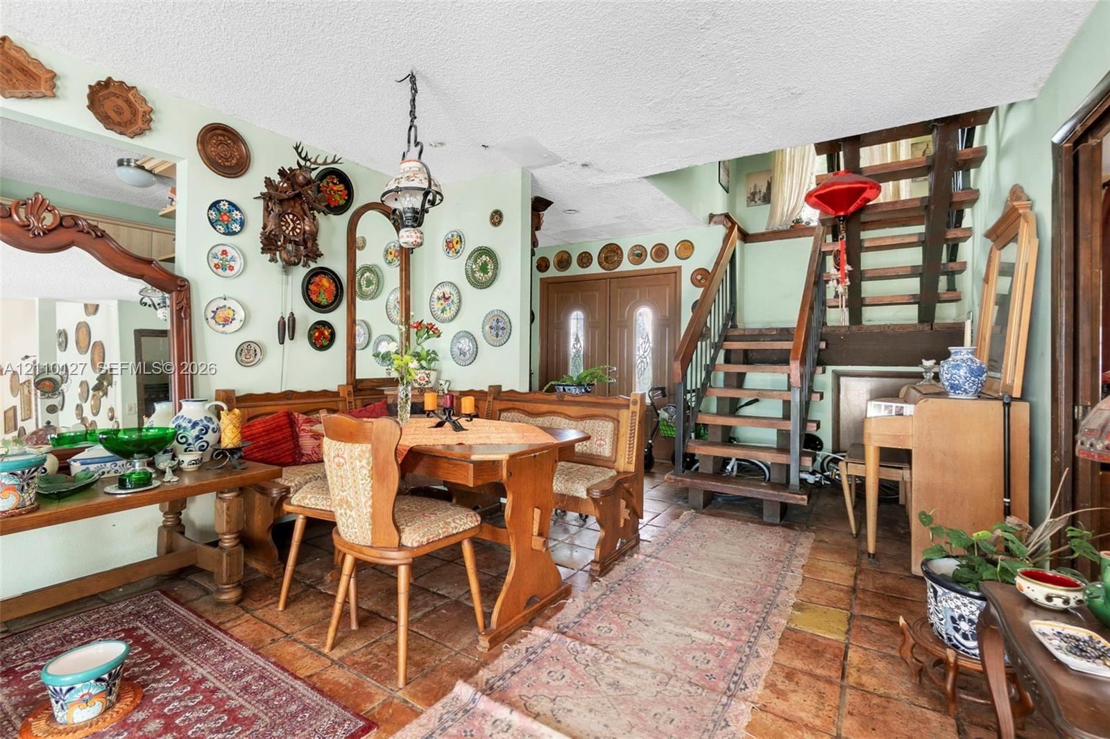 Interior featuring ceramic tile flooring, an open-tread wood staircase, and double-entry doors with glass inserts