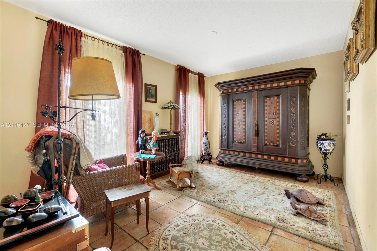 Interior room featuring dual floor-to-ceiling windows and terra-cotta tile flooring