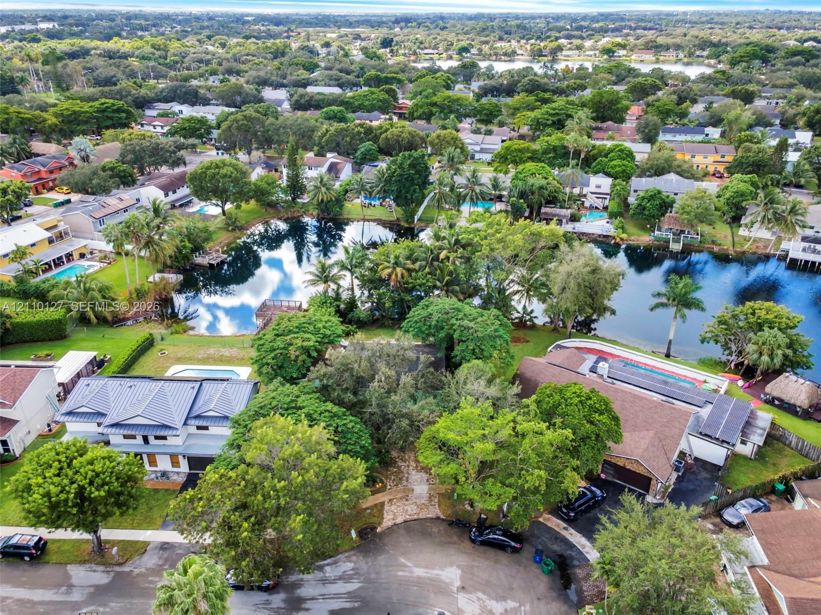 Aerial perspective featuring mature tree canopy, waterfront frontage, and established residential landscaping Aerial perspective featuring mature tree canopy, waterfront frontage, and established residential landscaping