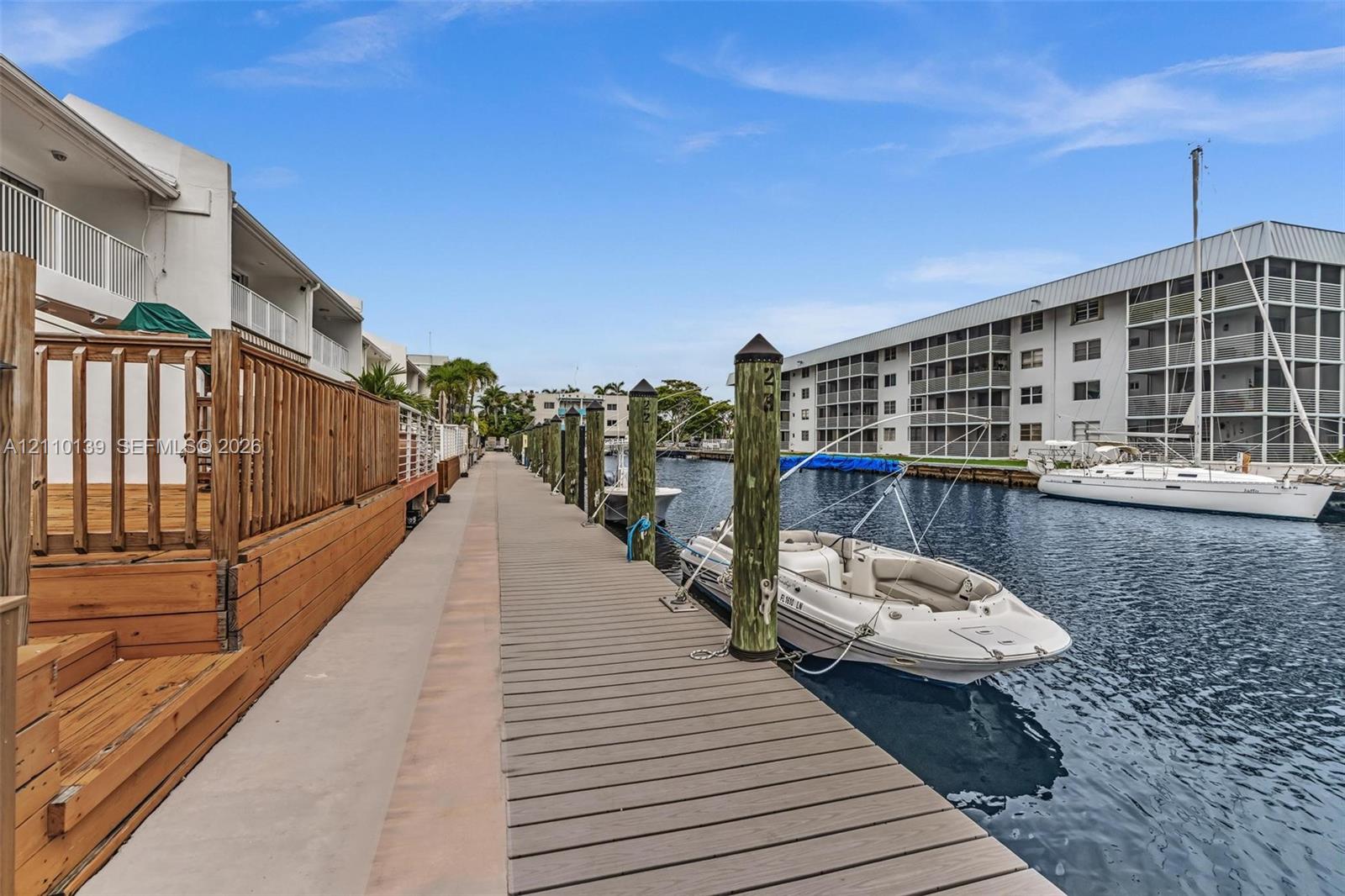 Waterfront composite dock featuring wooden pilings and bulkhead-level access to a deep-water canal