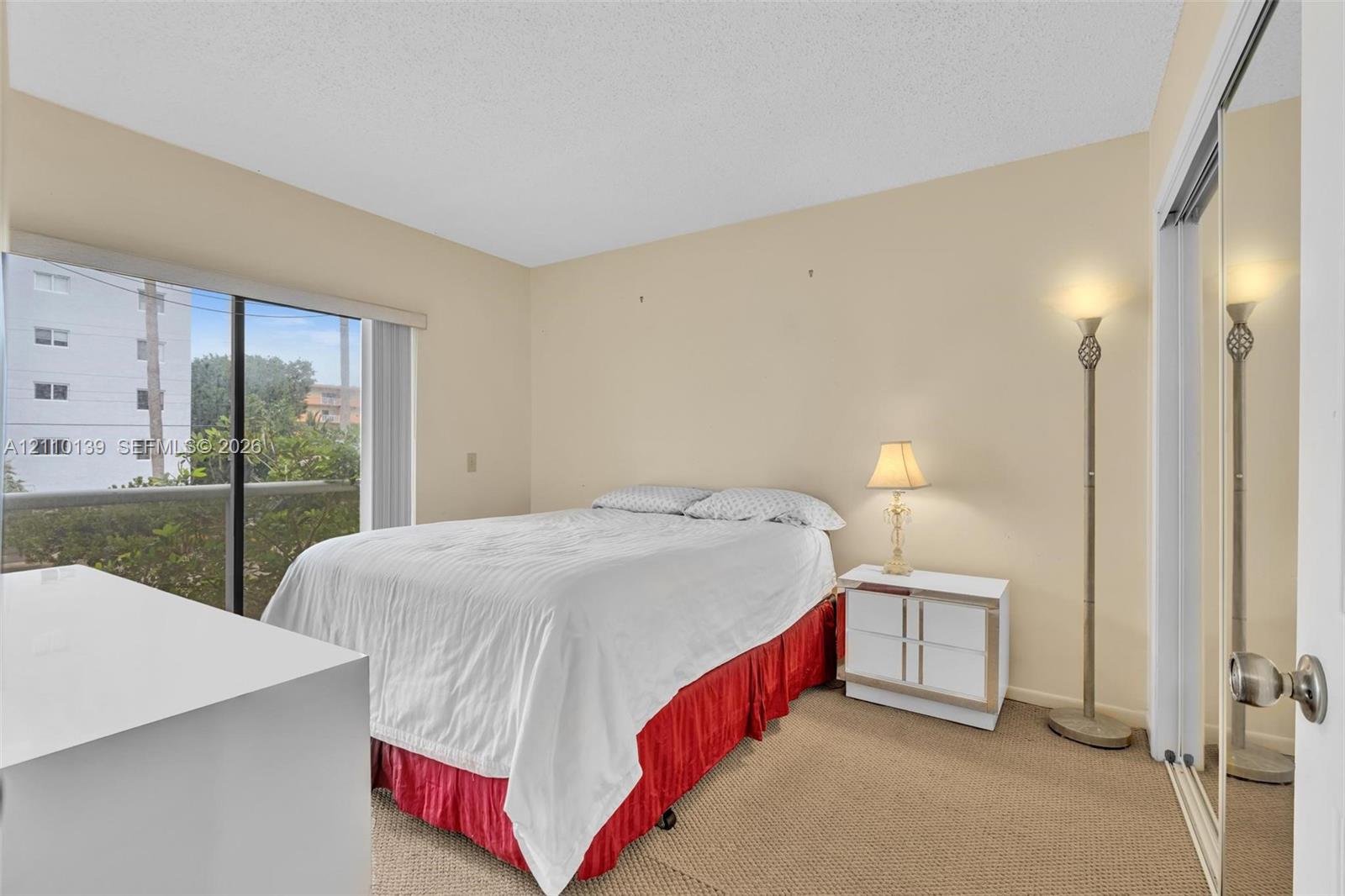 Floor-to-ceiling sliding glass door, carpeted flooring, and mirrored closet doors