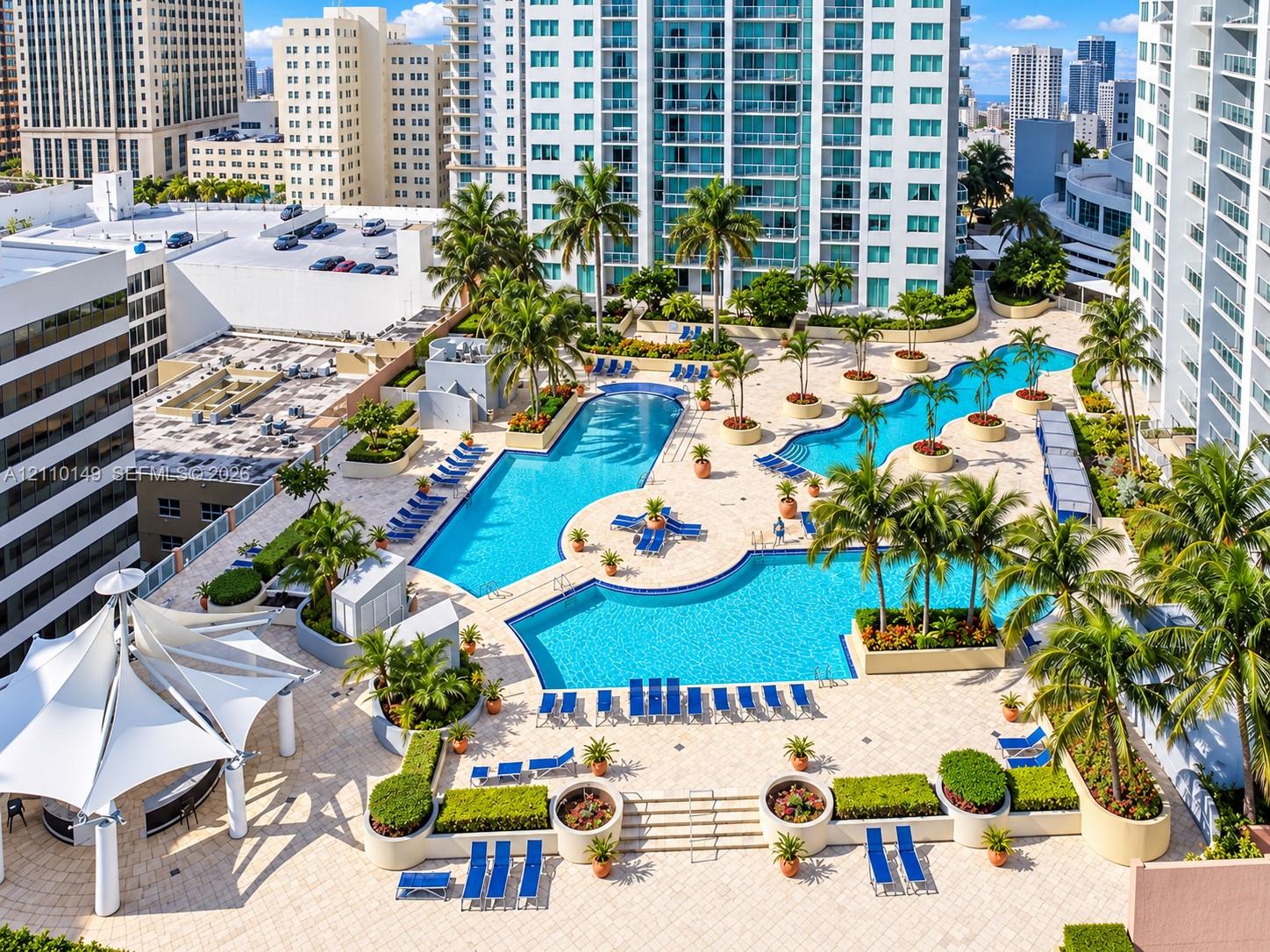 Multi-level swimming pools with hardscaped pool deck, palm tree landscaping, built-in structural planters, and tensile fabric shade structure Multi-level swimming pools with hardscaped pool deck, palm tree landscaping, built-in structural planters, and tensile fabric shade structure