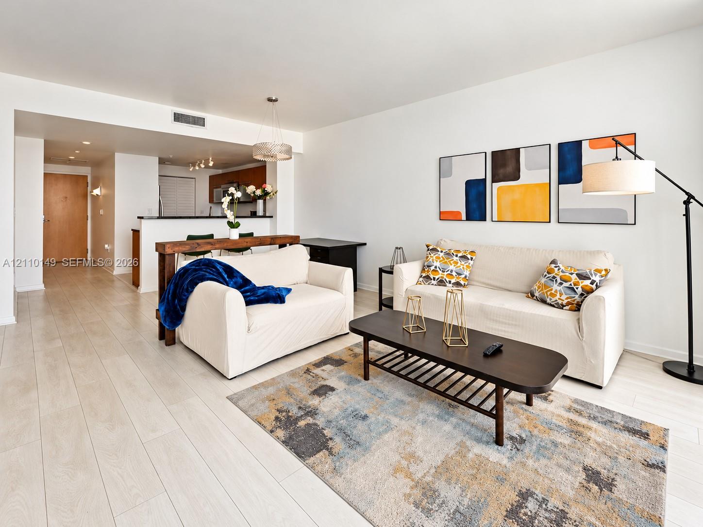 Open-concept interior featuring light-toned wood-finish flooring, recessed lighting, and a breakfast bar with wood-surfaced counter Open-concept interior featuring light-toned wood-finish flooring, recessed lighting, and a breakfast bar with wood-surfaced counter
