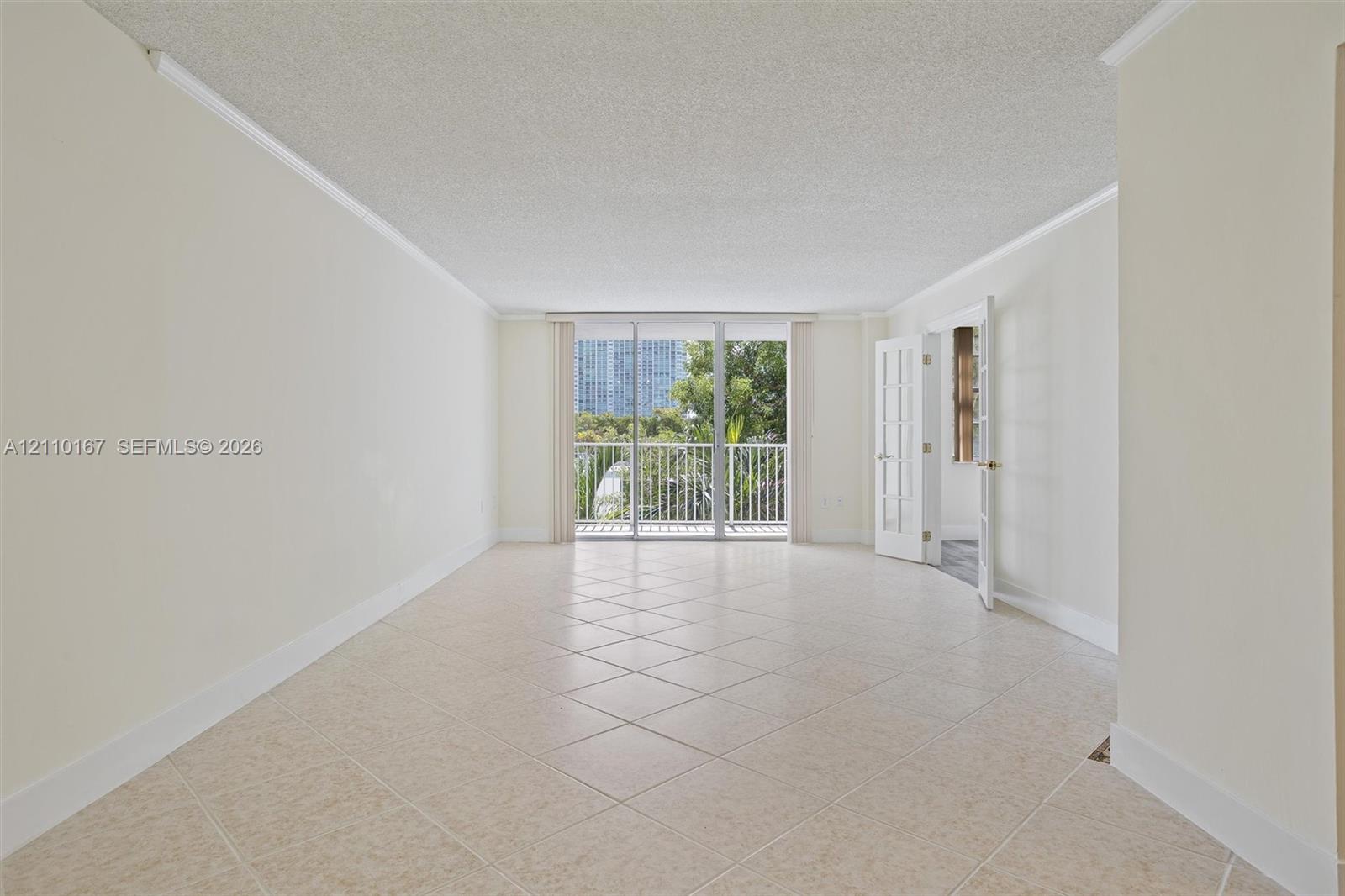 Neutral-toned ceramic tile flooring, crown molding, sliding glass doors, and French-style doors Neutral-toned ceramic tile flooring, crown molding, sliding glass doors, and French-style doors