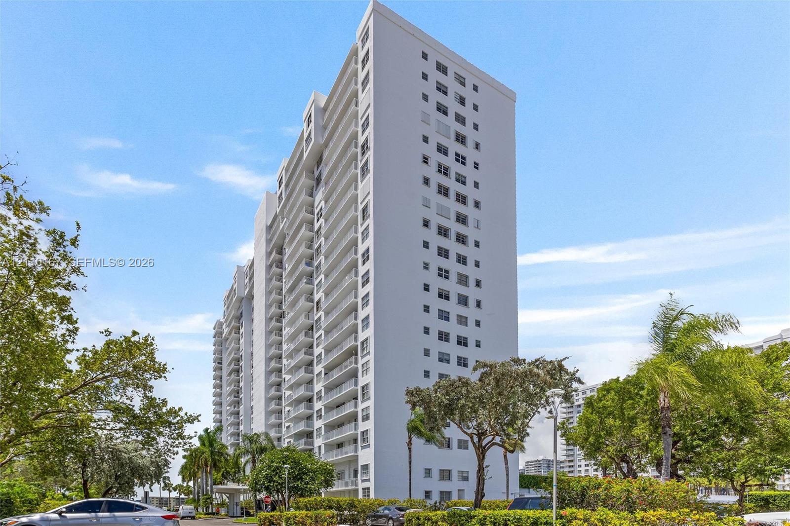 High-rise residential building featuring a concrete facade, tiered architectural structure, and multiple levels of private balconies High-rise residential building featuring a concrete facade, tiered architectural structure, and multiple levels of private balconies
