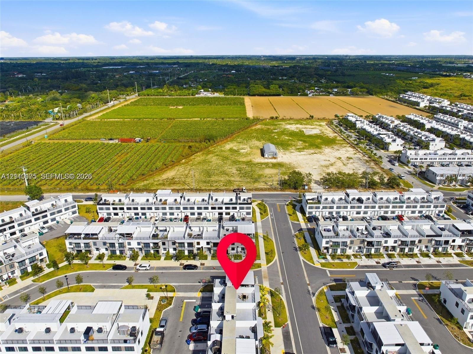 Aerial perspective of a multi-story residential community featuring paved street infrastructure and designated surface parking