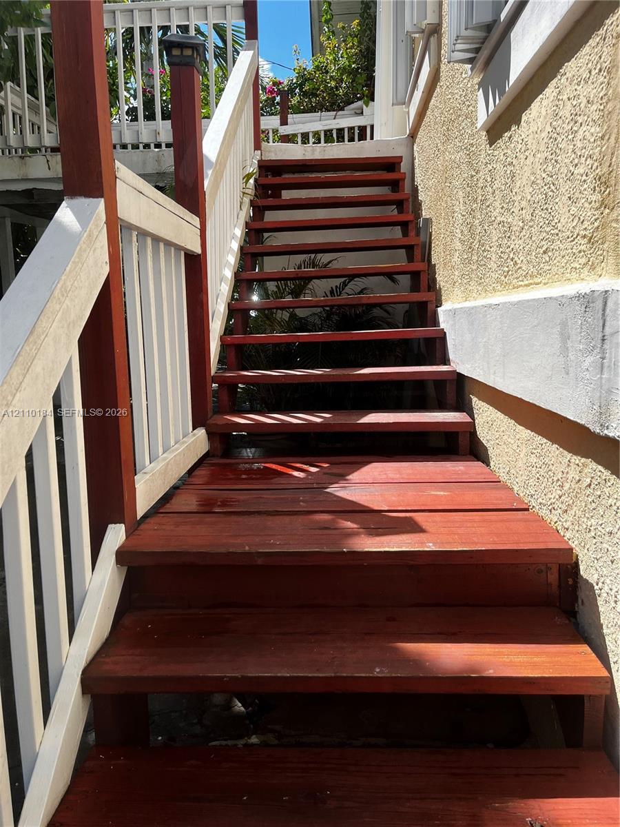 Exterior staircase featuring wood treads and a painted white wooden railing