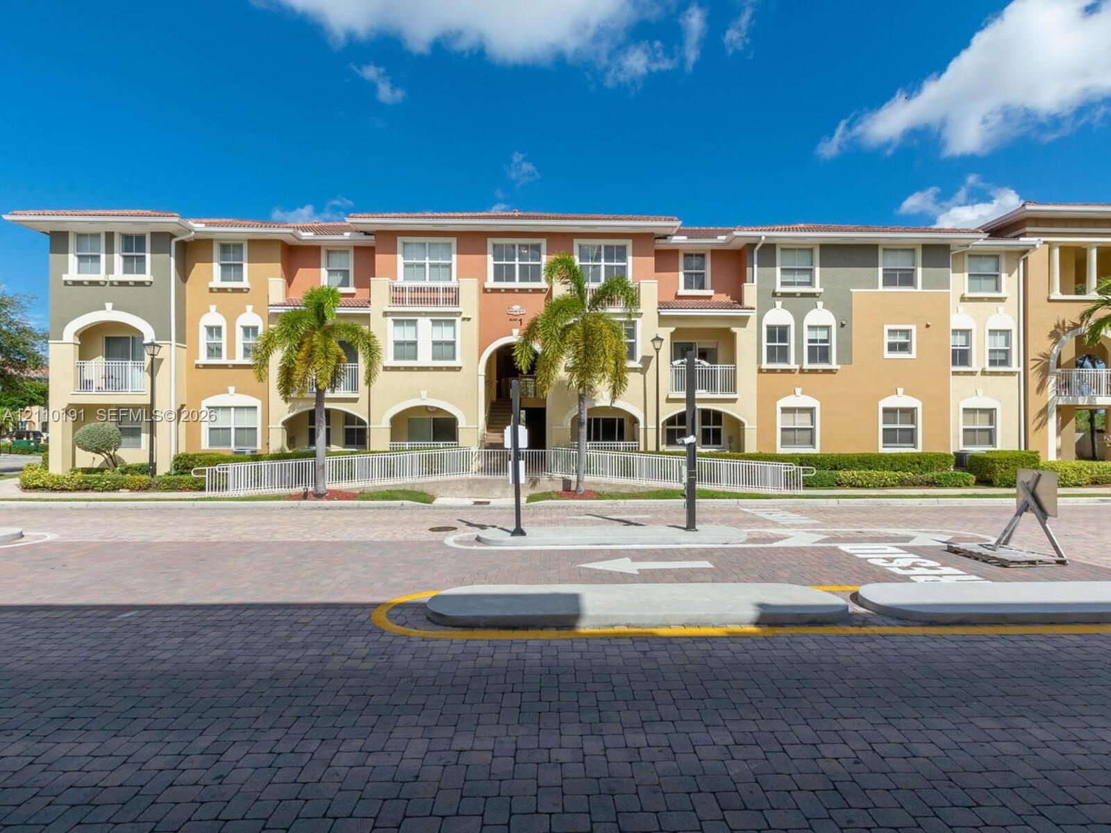 Multi-story Mediterranean-style exterior featuring stucco facade, arched architectural detailing, balcony enclosures, and decorative tile roof elements Multi-story Mediterranean-style exterior featuring stucco facade, arched architectural detailing, balcony enclosures, and decorative tile roof elements
