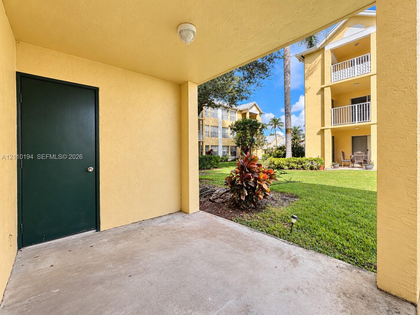 Covered concrete patio featuring an exterior storage closet, stucco finish, and access to a common lawn area