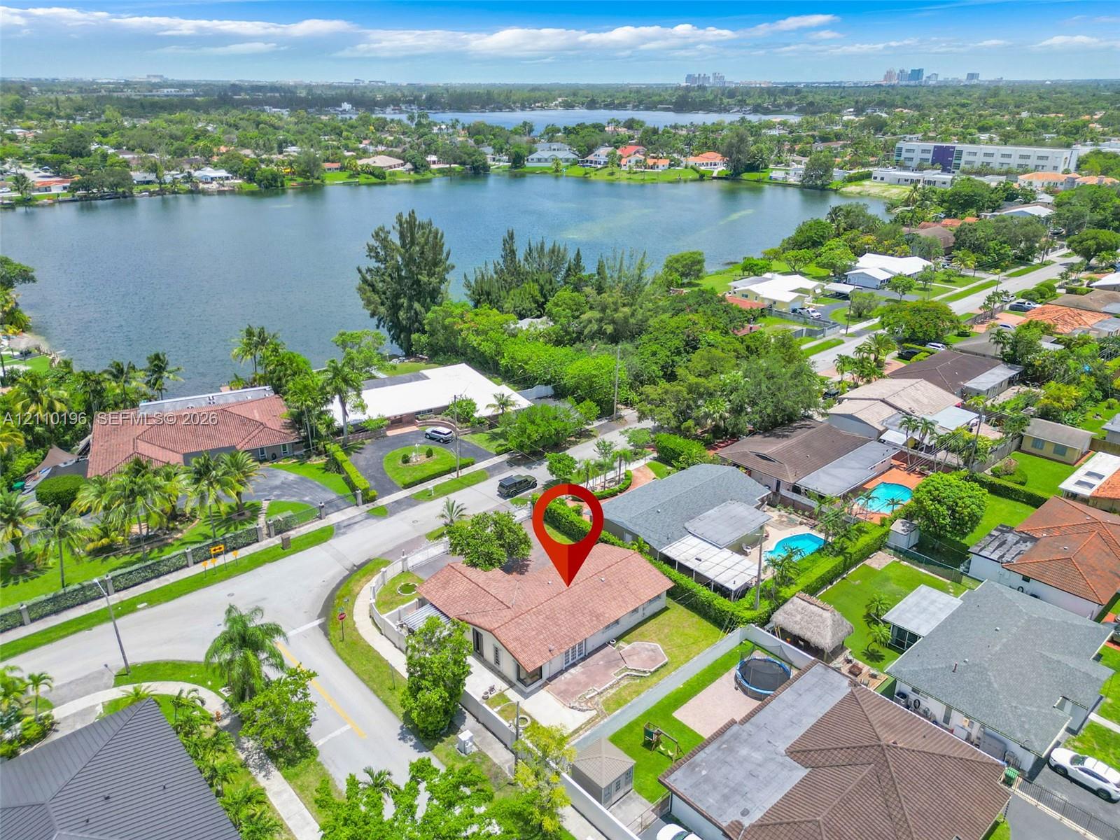 Aerial perspective featuring a shingle-style roof, corner lot placement, and proximity to a lakefront