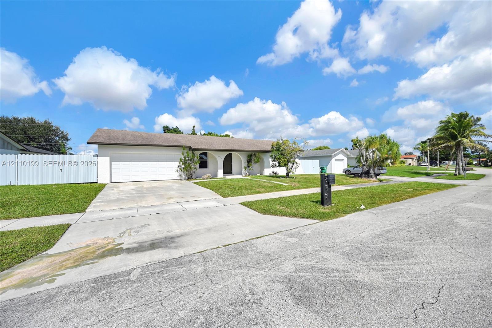 Single-story residence featuring a stucco exterior, arched covered entryway, two-car garage, and concrete driveway