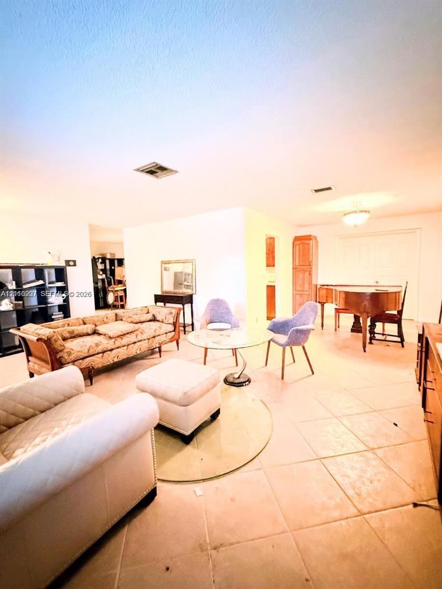 Open interior space featuring light-toned tile flooring, built-in floor-to-ceiling cabinetry, and recessed lighting