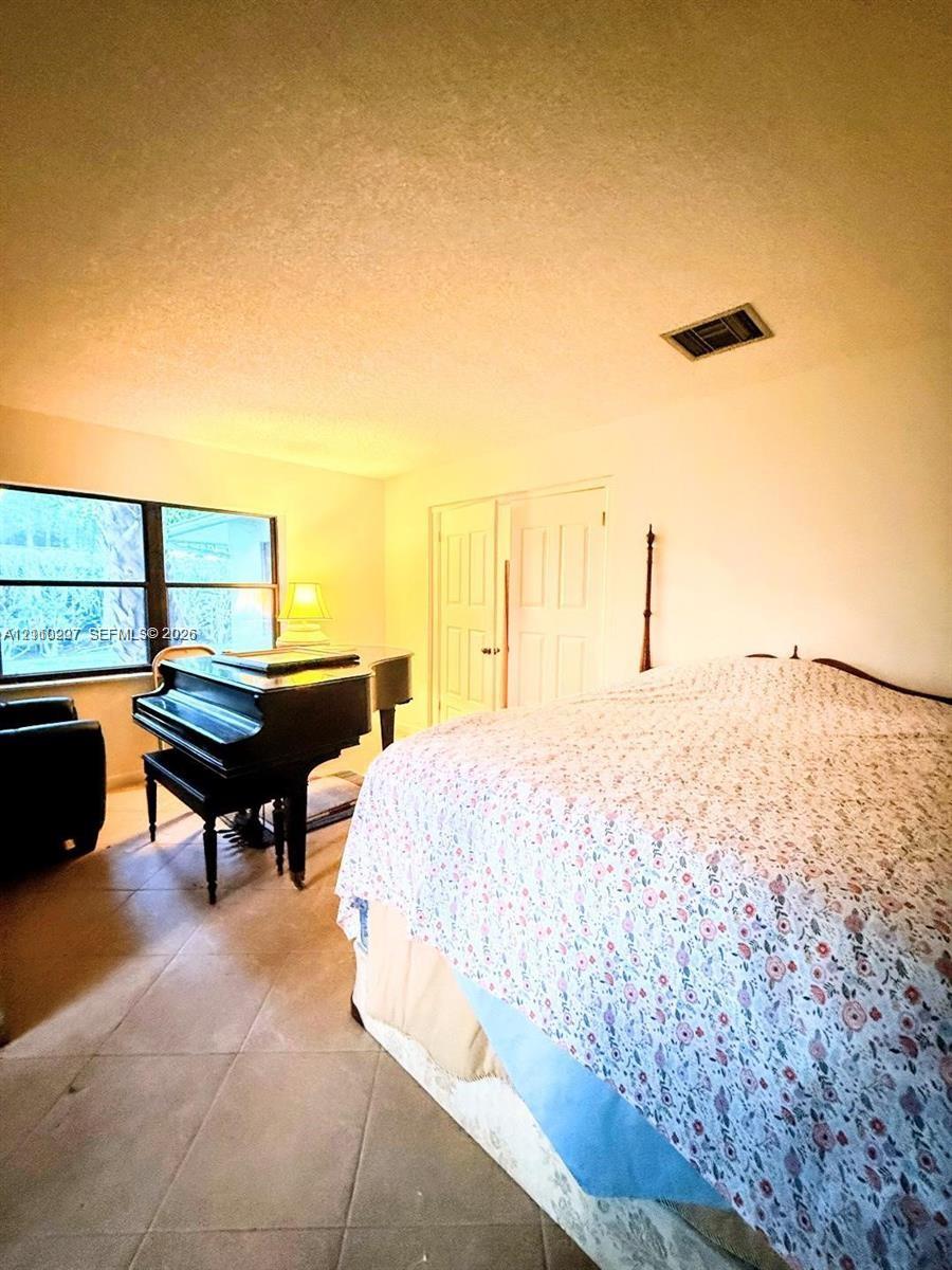 Room featuring ceramic tile flooring, neutral wall finish, and double-panel closet doors