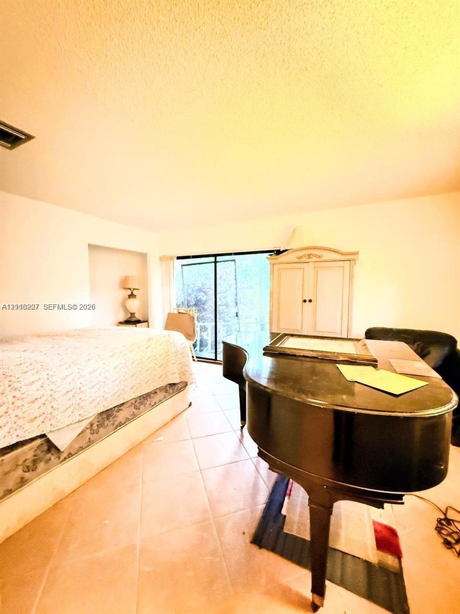 Ceramic tile flooring, built-in recessed wall shelving, and floor-to-ceiling glass sliding doors