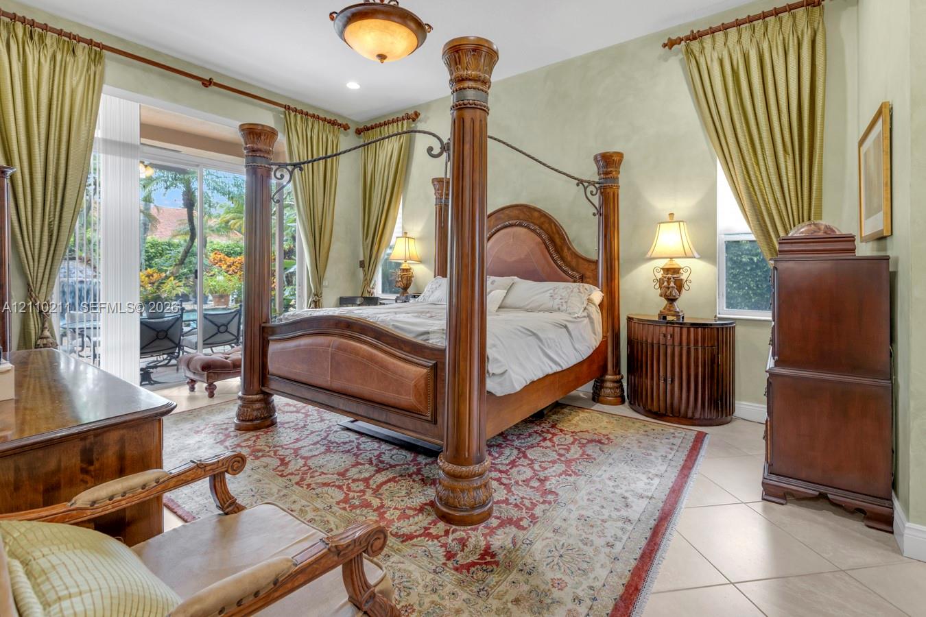 Spacious room featuring tile flooring, textured wall finishes, a decorative central ceiling light fixture, and sliding glass doors providing outdoor access