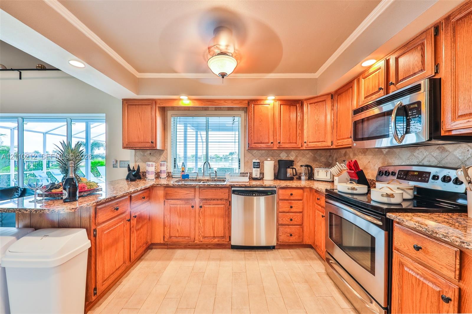 Kitchen featuring natural wood cabinetry, stone-finish countertops, stainless steel appliances, a tiled backsplash, and wood-finish flooring