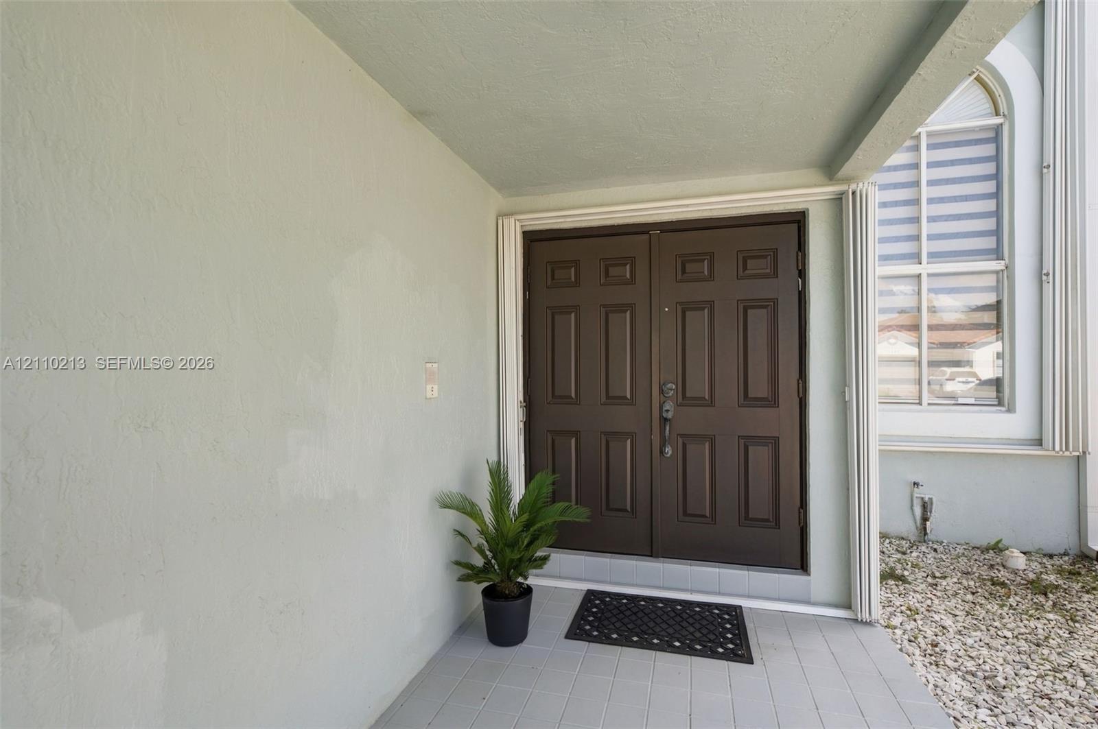 Covered entryway featuring double-door entry, paneled door design, and tiled porch flooring