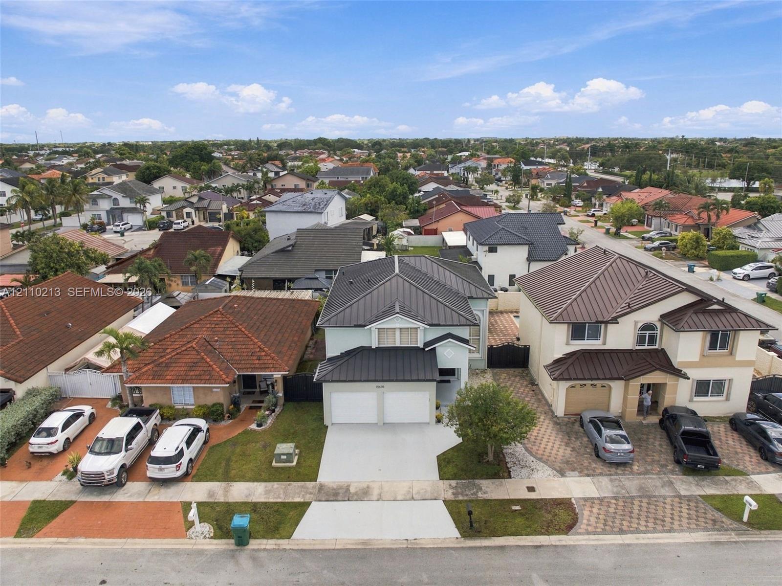 Two-story residence featuring a metal roof, two-car garage, and concrete driveway
