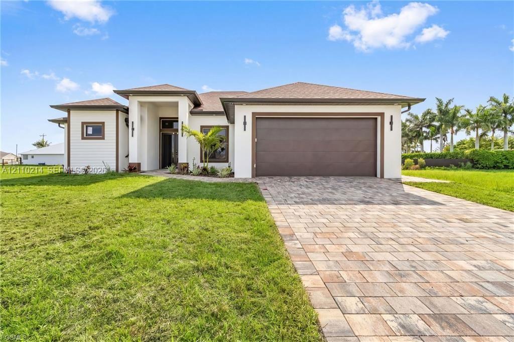 Single-story exterior featuring a neutral stucco facade, multi-textured siding, a paved stone driveway, a deep-set covered entryway, and an attached two-car garage Single-story exterior featuring a neutral stucco facade, multi-textured siding, a paved stone driveway, a deep-set covered entryway, and an attached two-car garage