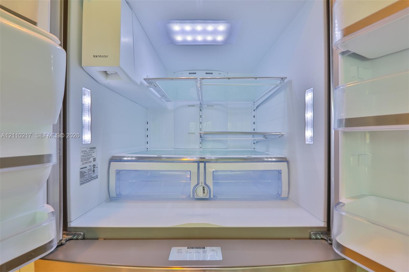 Stainless steel refrigerator featuring integrated LED interior lighting, adjustable glass shelving, dedicated climate-controlled storage drawers, and an in-door ice dispensing system