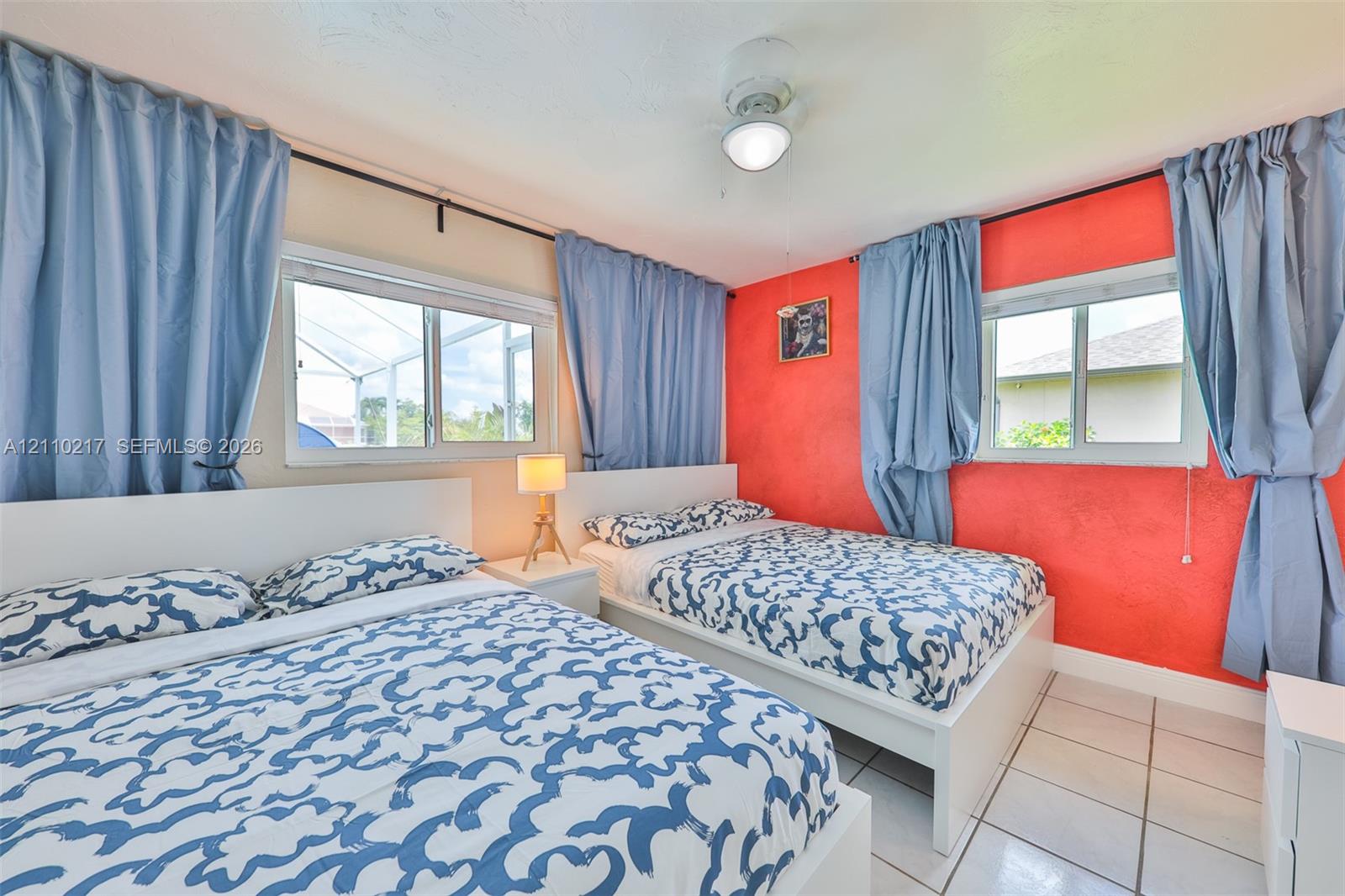 Room featuring dual horizontal sliding windows, tile flooring, and a central ceiling fan