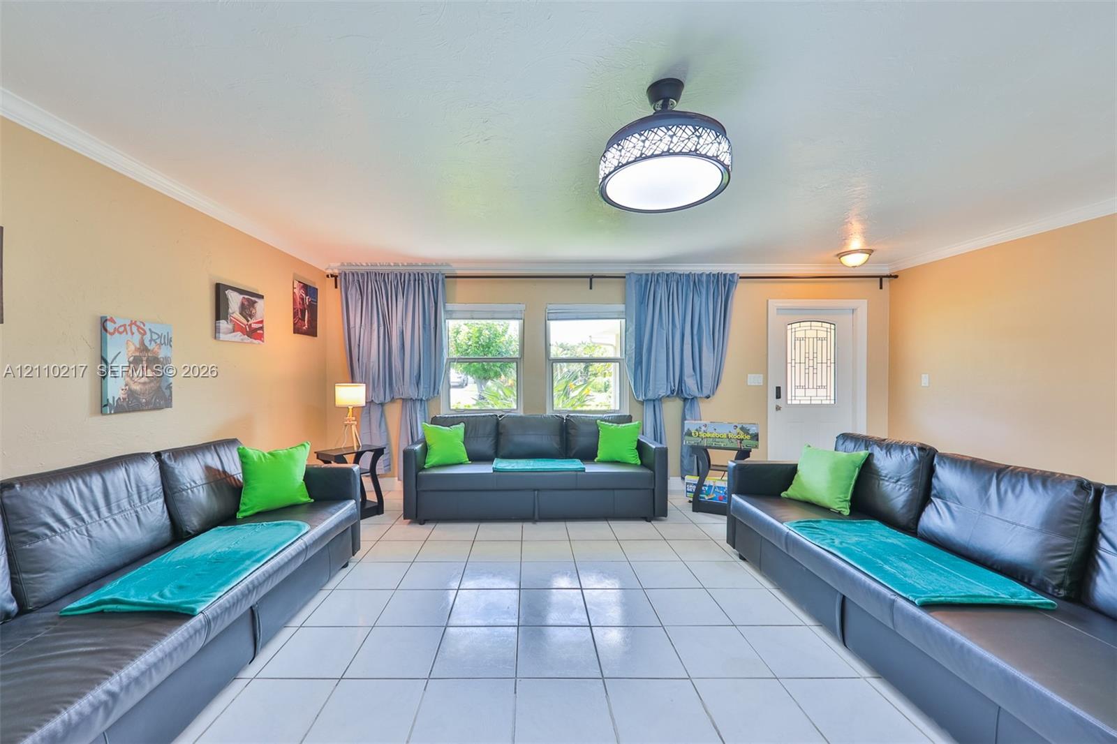 Living area featuring tile flooring, a decorative dome ceiling light fixture, and an exterior door with decorative glass paneling