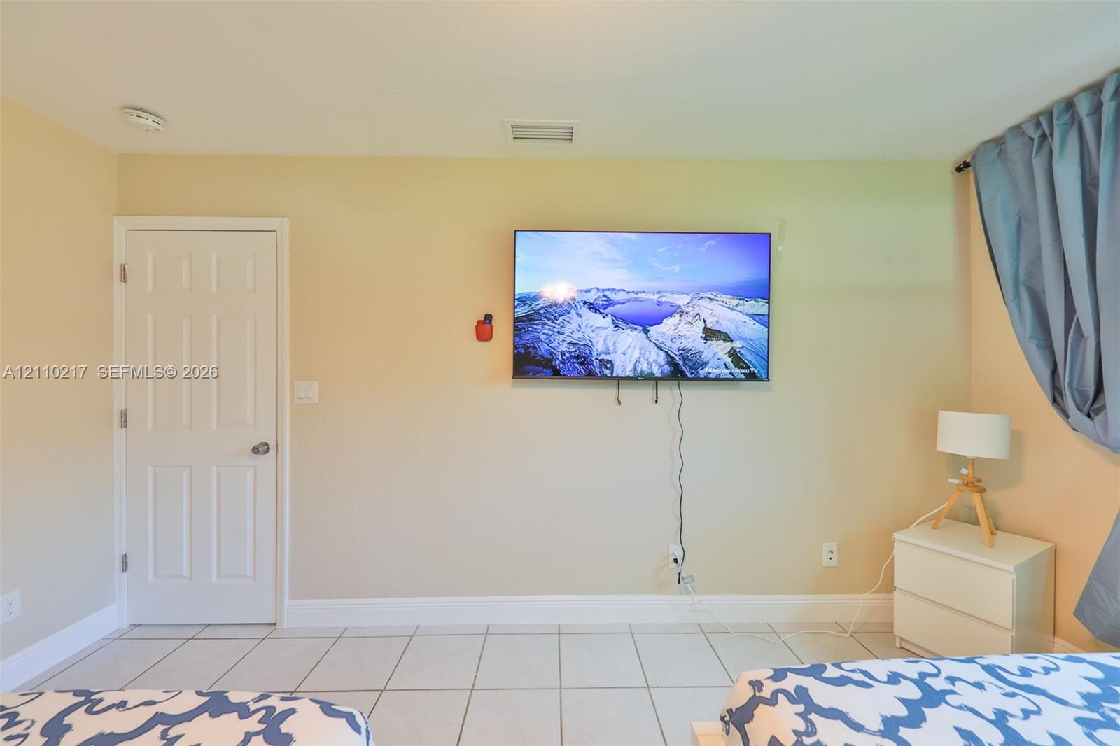 Interior space featuring large-format ceramic tile flooring and a solid-core interior door with brushed nickel hardware