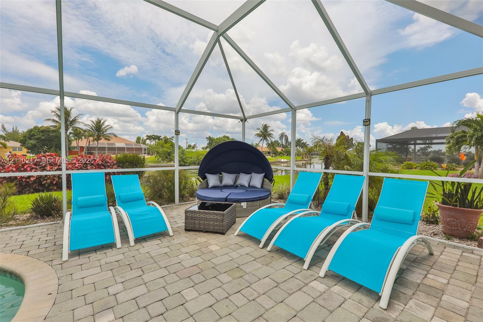 Screened lanai featuring paver flooring, a pool edge, and surrounding water frontage