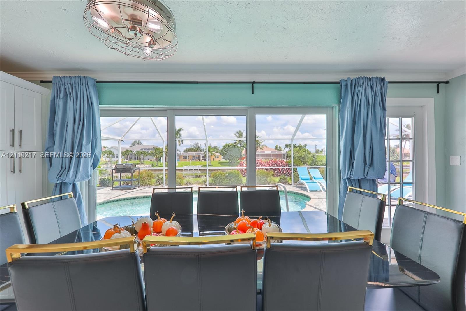 Large sliding glass doors with direct access to the exterior, recessed ceiling fan with cage-style fixture, and full-height built-in cabinetry