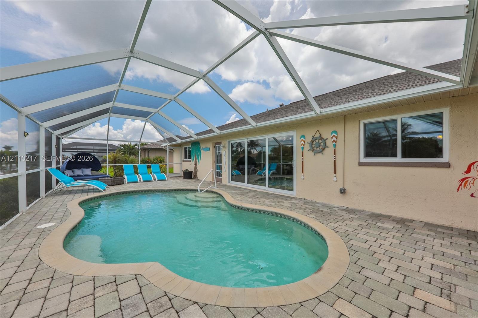 Screened-in patio featuring a paver deck and an in-ground swimming pool with integrated steps