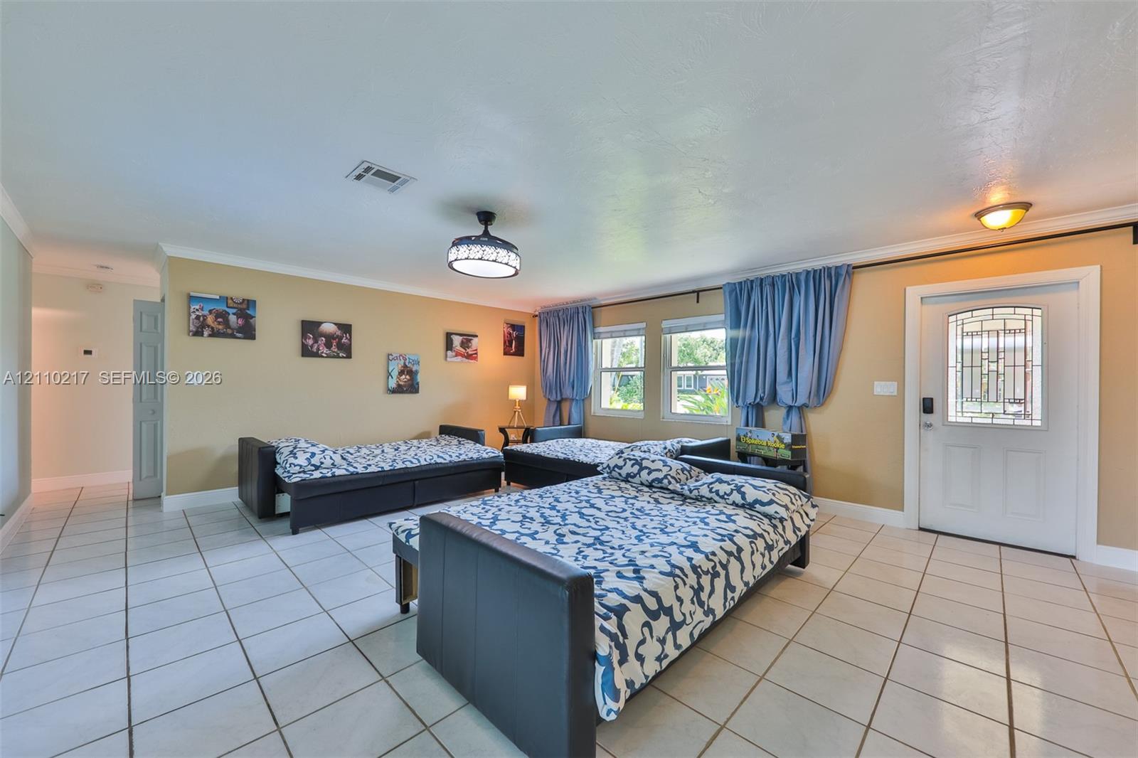 Ceramic tile flooring, white entry door with decorative glass inlay, ceiling-mounted light fixture, and two dual-pane windows