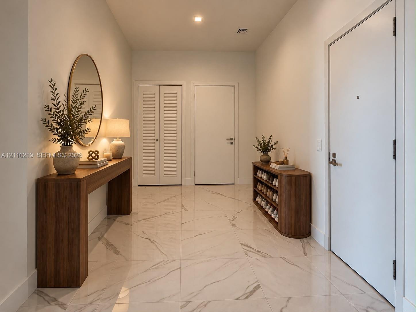 Entryway featuring large-format light-toned flooring with subtle veining, recessed lighting, and white interior doors including louvered closet doors