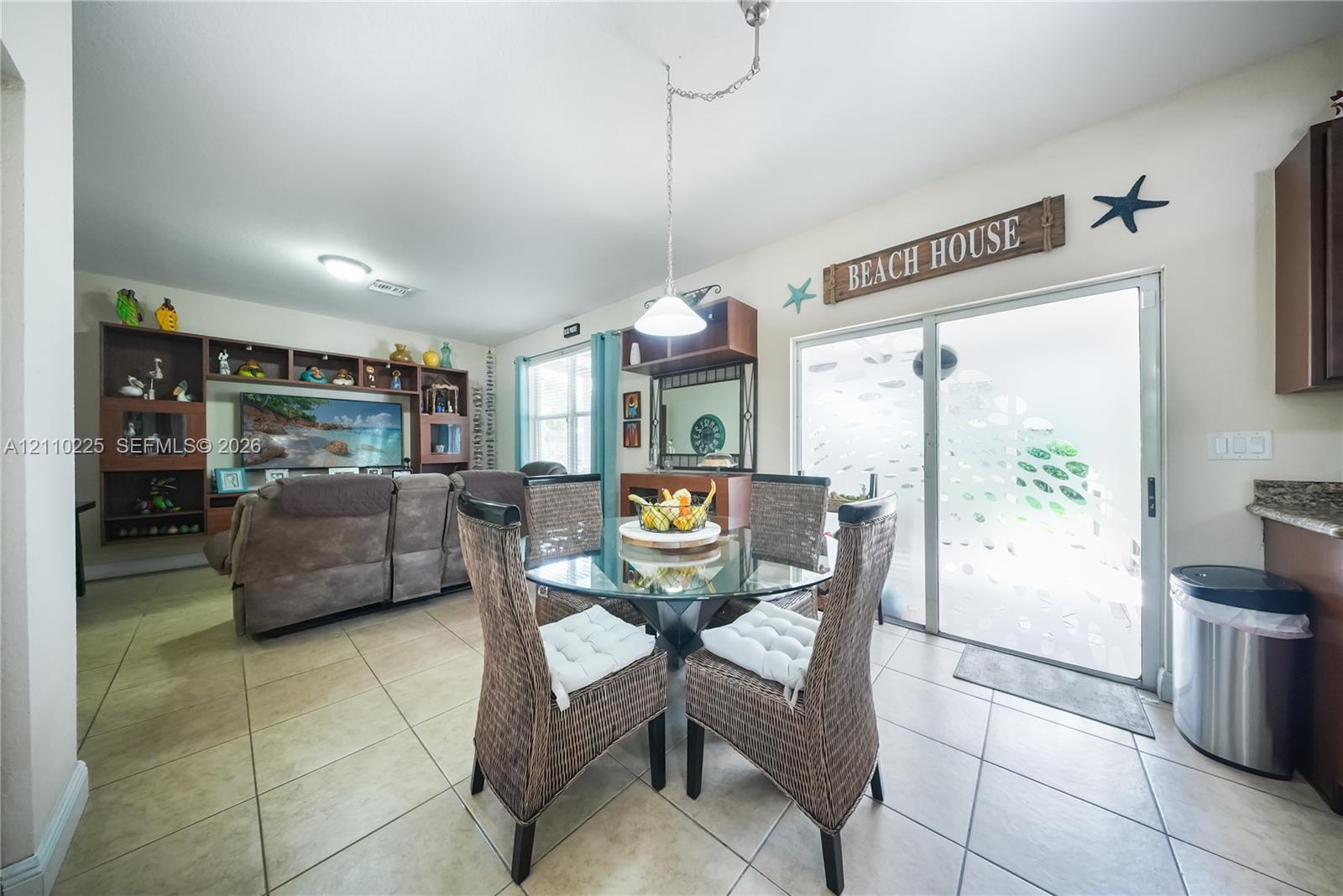 Tile flooring, large-format sliding glass door, and extensive built-in cabinetry featuring display shelving