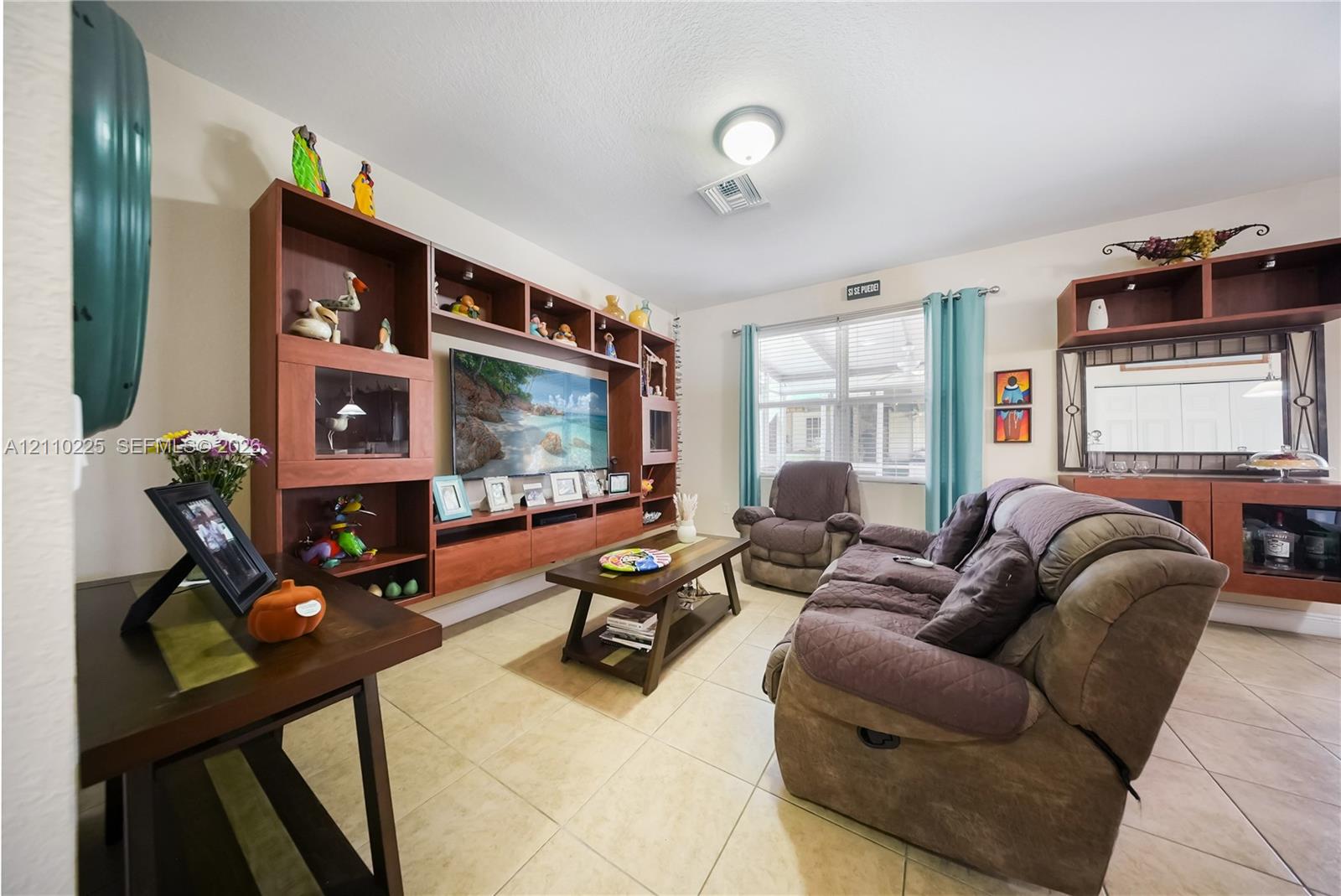 Large built-in wood-finish shelving unit, neutral tile flooring, and integrated wall-mounted cabinetry