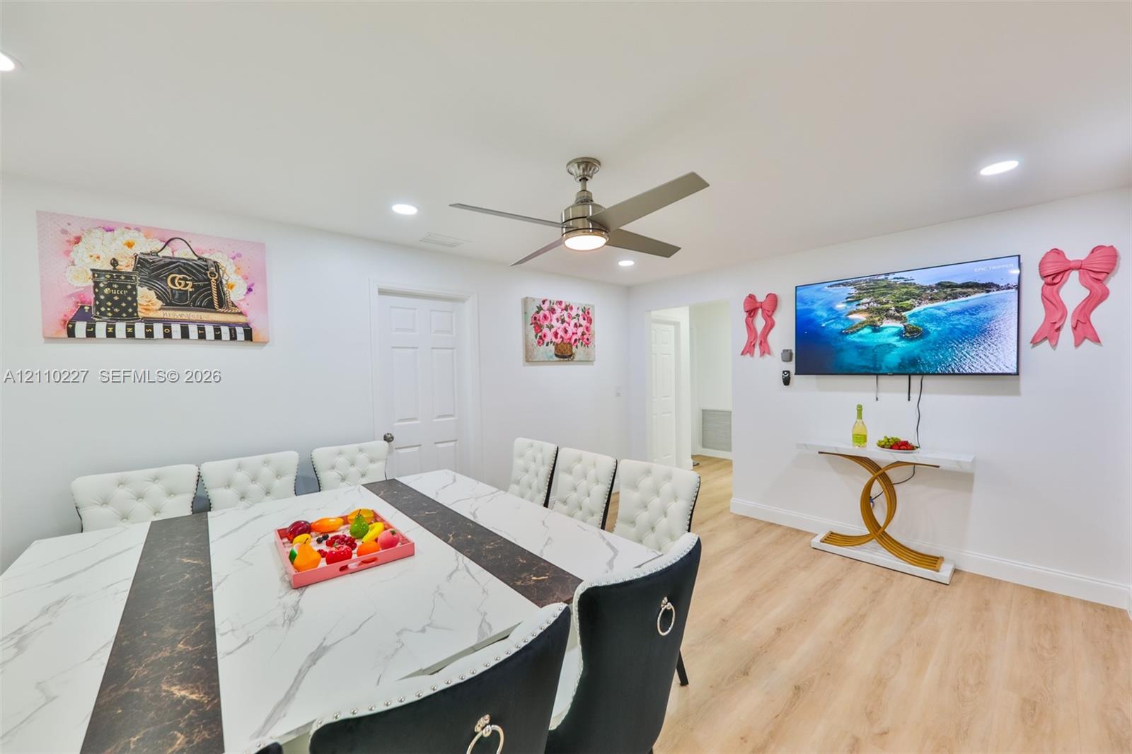Neutral interior space featuring wood-finish flooring, recessed lighting, and a modern brushed-nickel ceiling fan