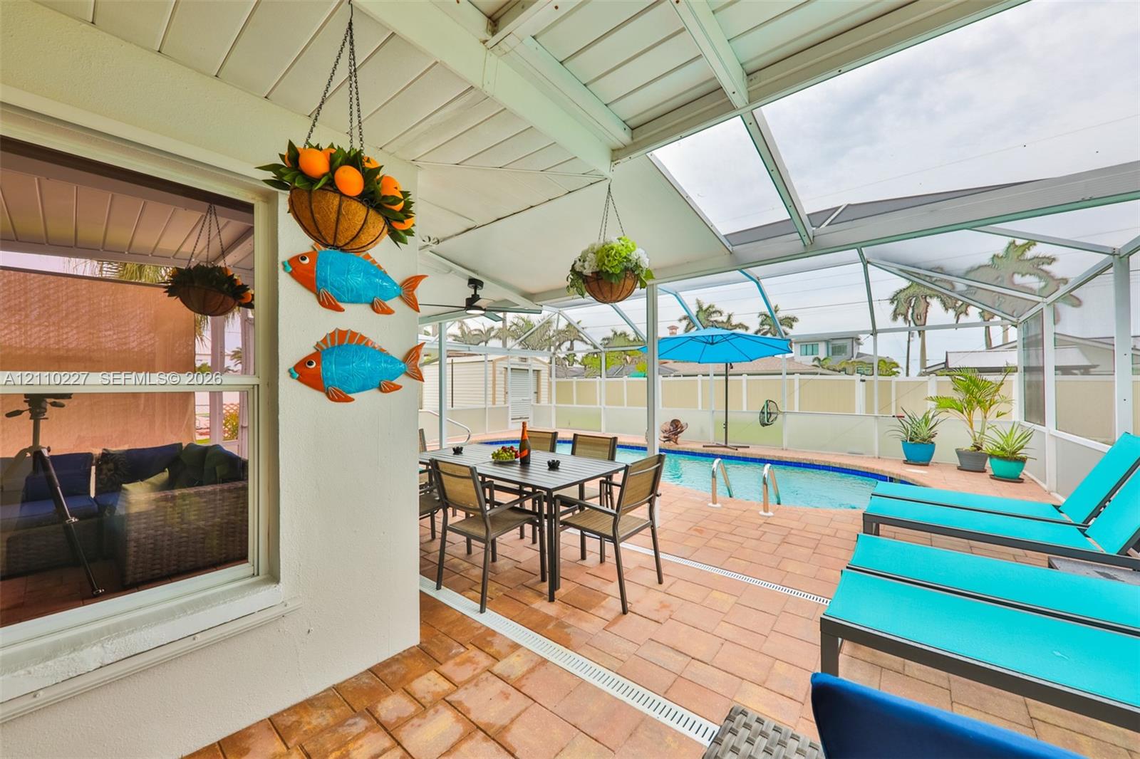 Screened lanai featuring paver flooring, a covered patio area, and an in-ground swimming pool