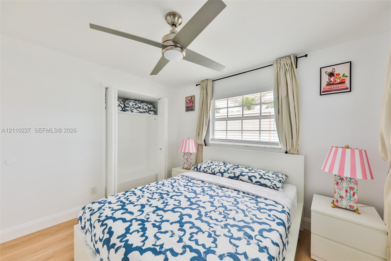 Wood-finish flooring, ceiling fan with integrated lighting, multi-pane window, and built-in closet