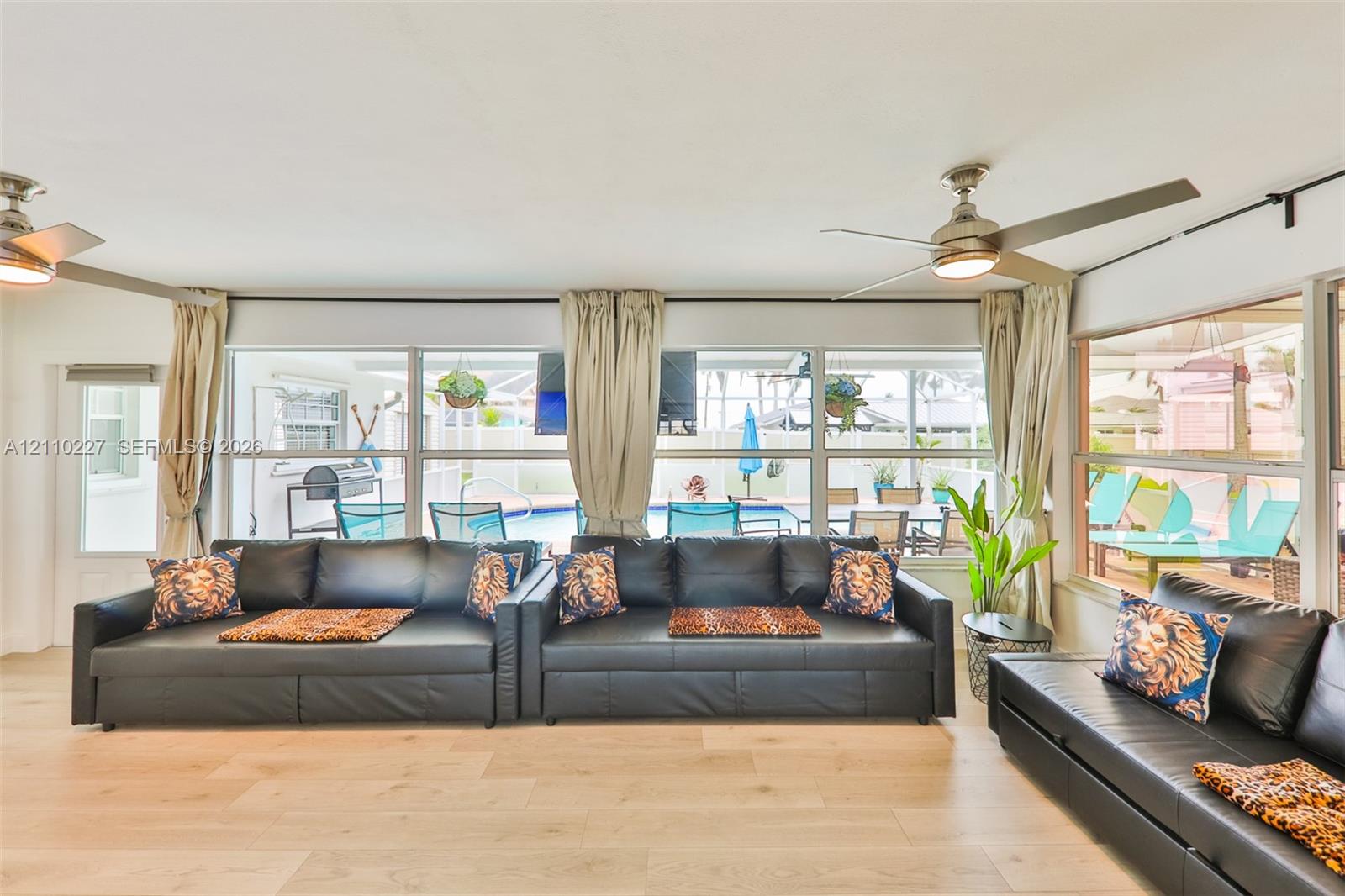 Wood-finish flooring, floor-to-ceiling windows, and dual ceiling fans