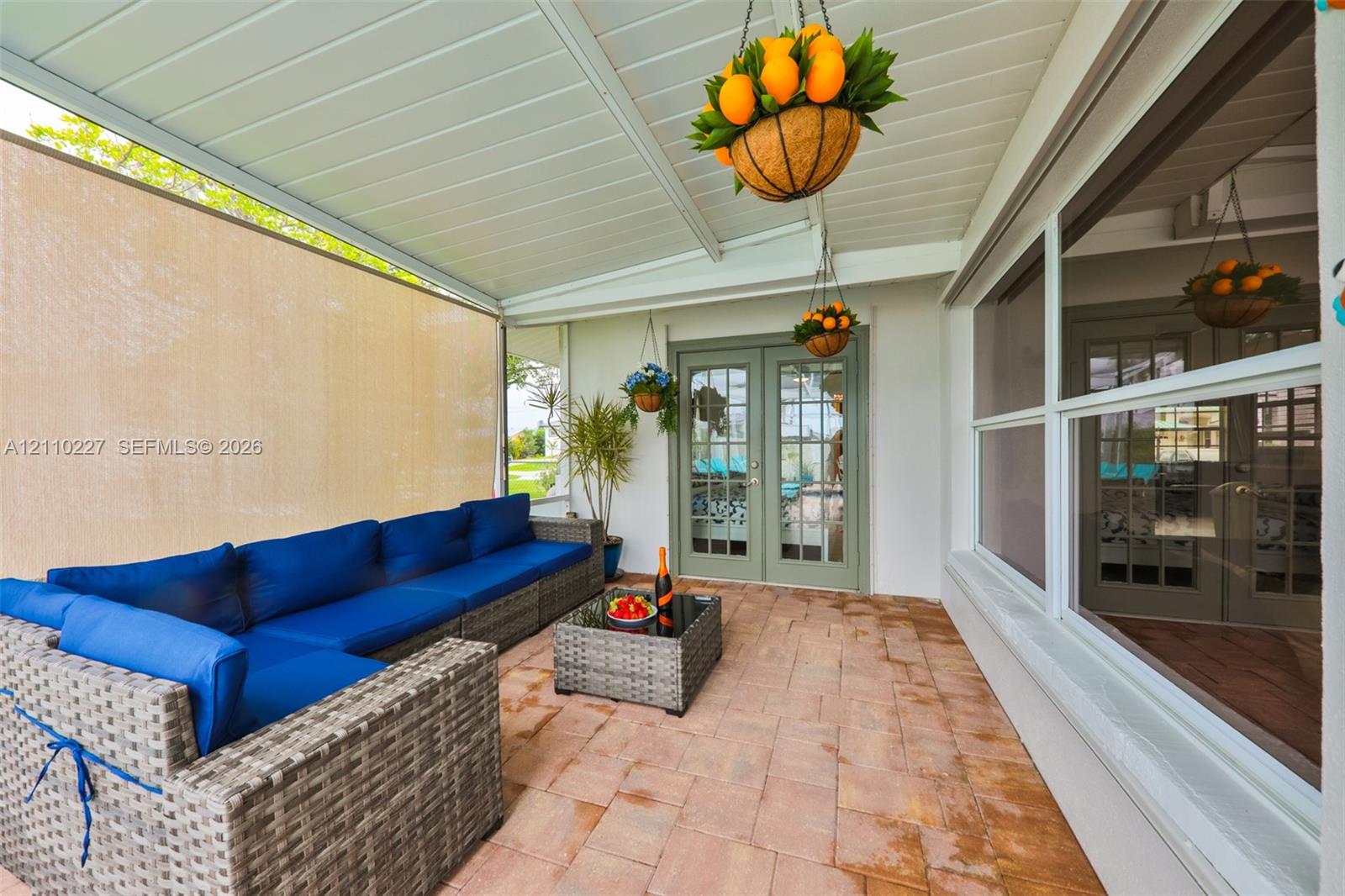 Covered patio featuring a paved floor, beadboard ceiling, privacy screening, and French doors