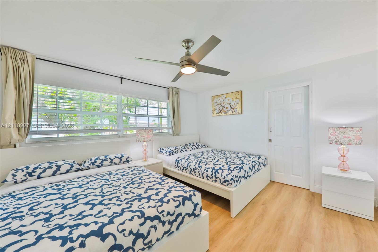 Wood-finish flooring, multi-pane windows, and a central ceiling fan with integrated lighting