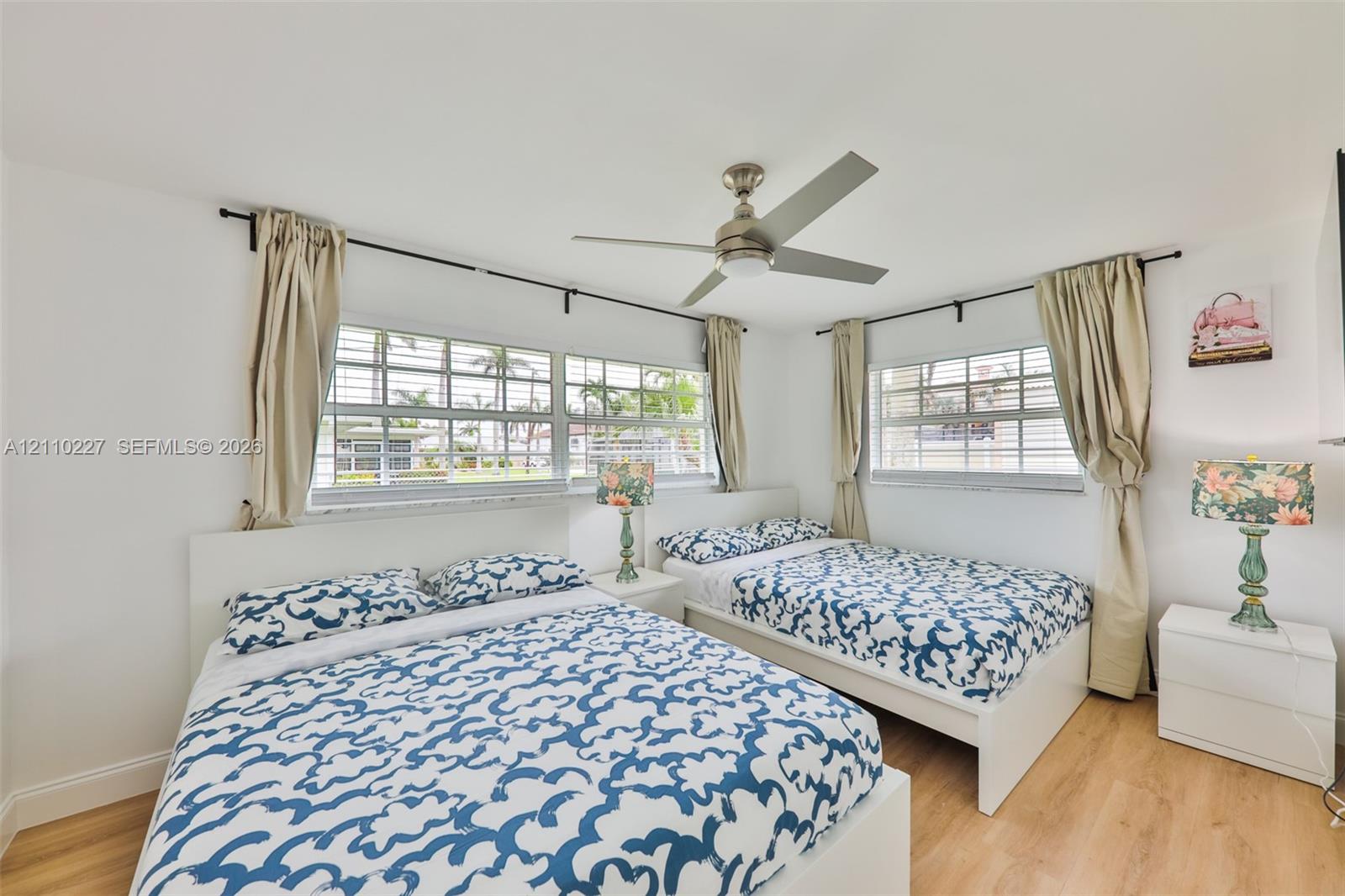 Wood-finish flooring, multi-pane windows with horizontal muntins, and a central ceiling fan